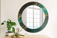 a round mirror sitting on top of a wooden table next to a potted plant