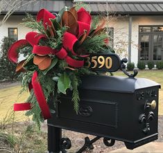 a mailbox decorated with greenery and red ribbon for the number 350 on it