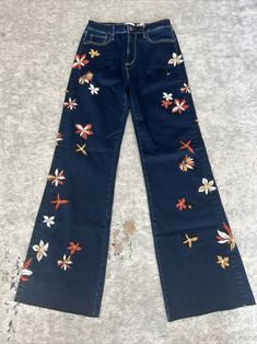 Elevate your denim game with these NWT Free People Driftwood Wide Leg Raw Hem Charlee Embroidrd Denim Jeans in size 26. The floral embroidery adds a touch of feminine charm to the dark wash and colorful design. The buton W. zipper closure and 98% cotton 2% spandex fabric ensure a comfortable and stretchy fit. The mid-rise and wide-leg style flatter any figure, while the 33" inseam and dark fabric wash add a trendy touch. These jeans are perfect for any occasion and will quickly become a staple in your wardrobe. Don't miss out on the chance to own these stylish and unique Driftwood jeans. Waist 28” inseam 33” rise 11” leg opening 22” Bohemian Mid-rise Flare Jeans For Spring, Bohemian Denim Blue Jeans For Spring, Embroidered Wide Leg Denim Blue Jeans, Embroidered Mid-rise Flare Jeans For Fall, High Rise Floral Embroidered Jeans, Fitted Dark Wash Embroidered Jeans, Mid-rise Embroidered Flare Jeans For Fall, Casual Embroidered Cotton Flare Jeans, Embroidered Blue Flare Wide Leg Jeans