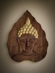 a buddha statue on the wall with its eyes closed