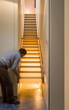 a man standing in front of a set of stairs with his hand on the ground