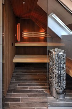 an indoor sauna with wooden benches and tile flooring in the corner, next to a skylight