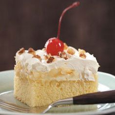 a piece of cake sitting on top of a white plate with a cherry on top