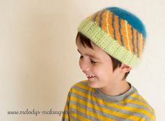 a young boy wearing a knitted hat with multicolored stripes on the top