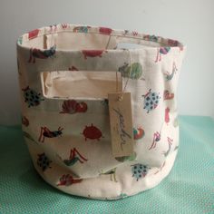 a fabric storage bag with an animal print on the front and bottom, sitting on a green tablecloth