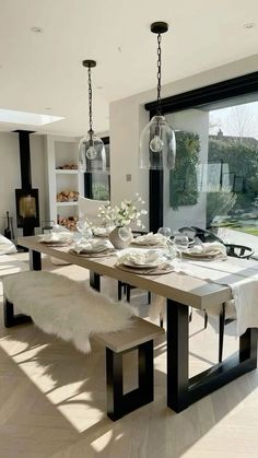 a dining room table and bench in front of a large window