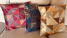 three decorative pillows are sitting on a couch