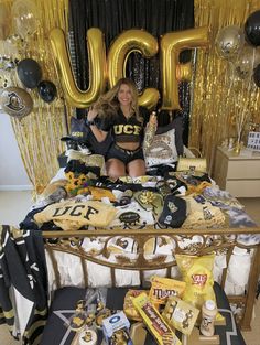 a woman is sitting on her bed surrounded by balloons and other items in the room