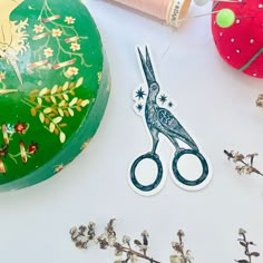 scissors and thread on a table with flowers