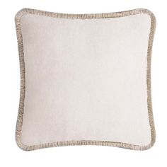 a white and beige pillow with fringe trim