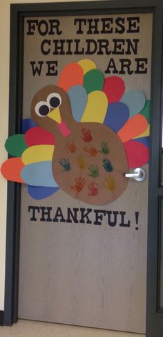 a door decorated with handprints and an image of a turkey that says for these children we are grateful