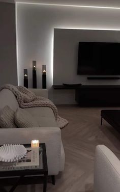 a living room filled with furniture and a flat screen tv mounted to the side of a wall