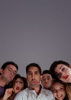 a group of people standing next to each other in front of a man with his mouth open