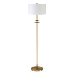 a gold floor lamp with a white shade on the base and a round light fixture