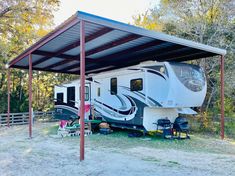 an rv is parked under a metal awning