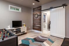 a living room with a television, foo - ball table and entertainment center in it