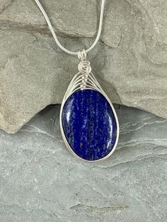 This natural Lapis Lazuli necklace is gorgeous! Lapis Lazuli stone has been valued for centuries and Prized for its vibrant royal blue color.  I chose to enhance this beautiful smooth stone with a woven silver wire design to let the natural beauty of the gemstone shine. Pair this flattering necklace with your favorite sweater or blouse, dressed up or down, the possibilities are endless!This necklace is handmade by me with a genuine smooth Lapis Lazuli stone. The necklace you will receive will be Handmade Oval Lapis Lazuli Necklace, Blue Oval Pendant Necklace With Spiritual Style, Blue Oval Pendant Necklace With Natural Stones, Blue Oval Necklace With Natural Stones, Blue Stones Jewelry, Wire Design, Lapis Lazuli Jewelry, Lapis Lazuli Pendant, Lapis Lazuli Necklace