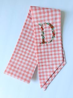 two pink gingham cloths with the letter d on them