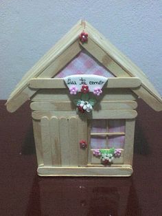 a small wooden house with flowers and hearts on the window sill that says, let it be loved