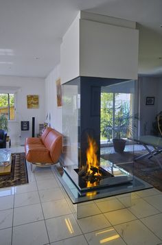 a living room filled with furniture and a fire place in the middle of the room