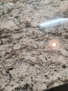 a marble counter top with a wine glass on the side and an empty bottle next to it