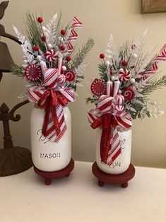 two mason jars decorated with candy canes and greenery