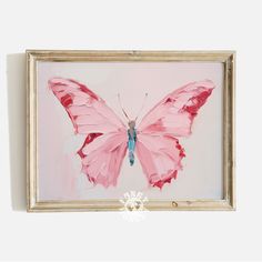 a painting of a pink butterfly on a white wall with a gold frame and blue eyes