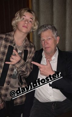 an older man and young woman posing for the camera with their fingers up in front of them