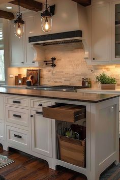 a kitchen with white cabinets and wooden flooring, lights hanging from the ceiling over the island