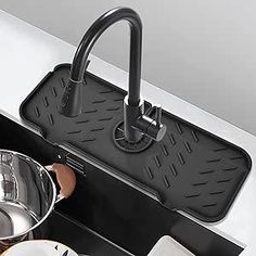 a kitchen sink with pots and pans on it