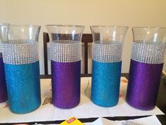 four purple and blue glasses sitting on top of a table