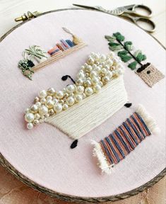 a close up of a embroidery on a hoop with scissors and other items in it