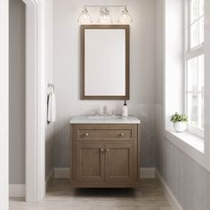 a bathroom vanity with a mirror above it and two lights on the wall next to it