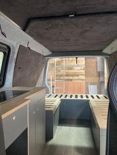 the interior of a camper van with wood flooring and storage area in it