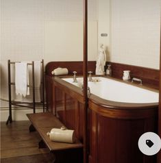 a bathroom with wooden floors and white walls