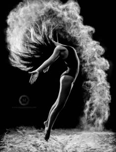 black and white photograph of a woman in the air with her hair blowing behind her