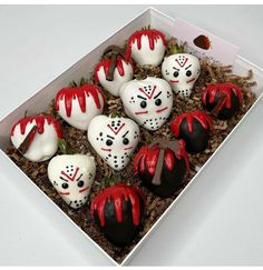 a box filled with white chocolate covered in red and black frosted marshmallows