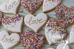 heart shaped cookies with love written on them and sprinkles in the shape of hearts