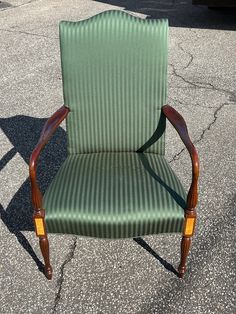 a green chair sitting on top of a parking lot