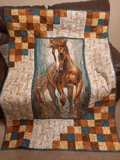 a quilt with a horse on it sitting on a couch