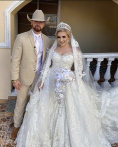 a man and woman in wedding attire standing next to each other on the steps outside