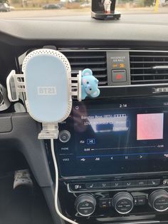 an electronic device is attached to the dashboard of a car with a teddy bear on it