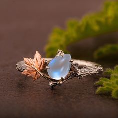 A handmade twig and maple leaf ring set with a natural pear shaped moonstone of high quality. The grooves creating the twig texture on the band are plated with black rhodium to add contrast to the design. The ring is made with any of the available metals you select. All of the metals we use are 100% recycled. The moonstone is 100% natural moonstone of high quality measuring 7mmX5mm If you have any questions please feel free to ask :) -----------------------VARIATIONS---------------------- The ri Nature-inspired Moonstone Ring, Opal Moonstone, Twig Ring, Moonstone Engagement, Moonstone Engagement Ring, Magical Jewelry, Wedding Bridal Jewellery, Tiny Diamond, Leaf Ring