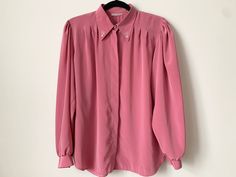 "Lovely dusty pink office blouse with a glamorous collar featuring crystals and pearls. Button down closure with pearl buttons at the sleeves and neck. 100% polyester. The fabric has a slight sheen to it, and is quite silky and pleasant. Size tags says vintage SZ 40, fits a modern large, but please consult measurements for accuracy. Excellent vintage condition. Brand : Betty Barclay Circa : 1980s Color : Pale Pink/Peach Women's size estimate : Large Made in Finland Measurements (lying flat): Pit to pit: 22.4\" / 57 cm Length: 26.7\" / 68 cm Sleeve: 26.7\" / 68 cm (from neckline to cuff) Sleeve inseam: 16.9\" / 43 cm Condition: excellent vintage, no flaws to note. Please note that color may slightly differ from picture. Please check measurements to ensure a proper fit. SHIPPING * I ship wor Dusty Pink Office, 80s Office, Office Blouse, Pink Office, Pearl Crystal, Pink Peach, Pink Blouse, Pearl Buttons, Casual Shirt