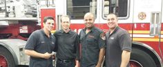 three men standing in front of a fire truck