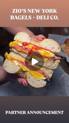 a person holding a sandwich in their hand with the words'zo's new york bagels + deli co '