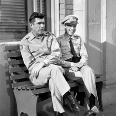 two men in uniforms sitting on a bench