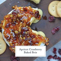 apricot cranberry baked brie on a cutting board with crackers