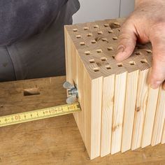 a man is measuring the height of a wooden block