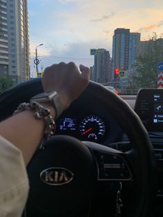 a person driving a car with their hand on the steering wheel and other vehicles in the background